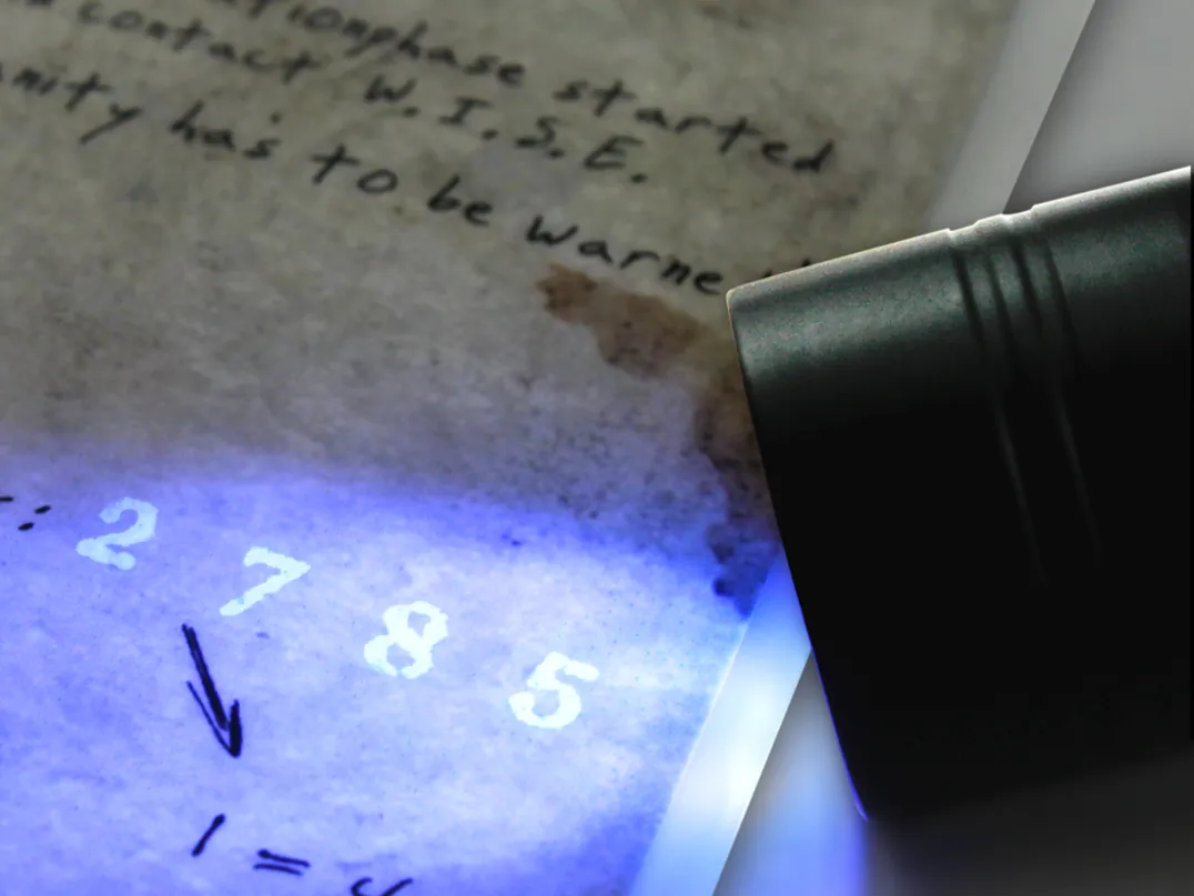 Une lampe révèle des chiffres cachés sur un document de mission